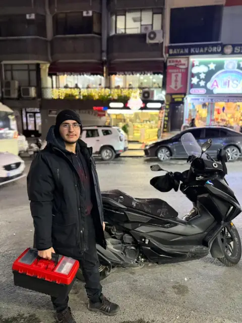 Çilingir ustası, motoru ve alet çantasıyla sokakta